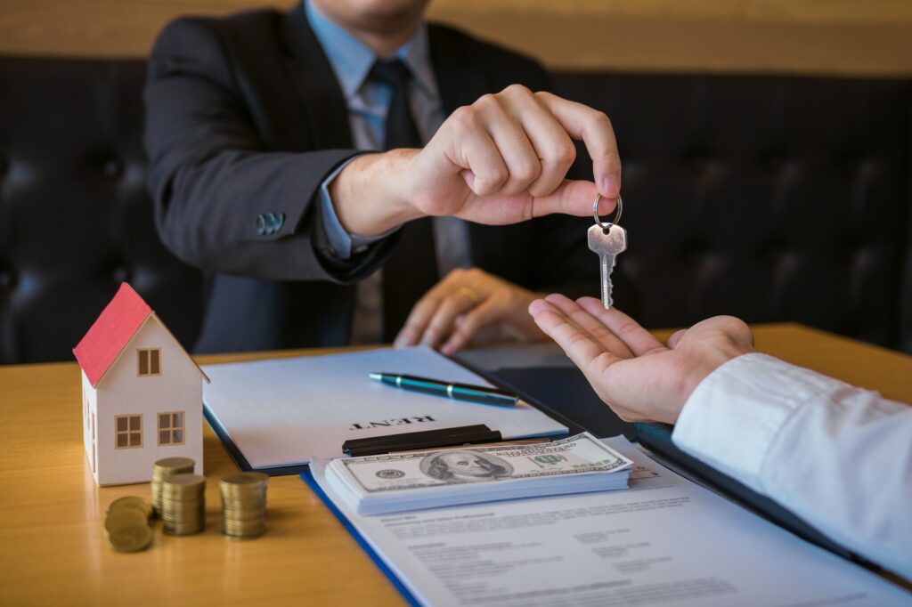 Salesman house brokers provide key to new homeowners in office.